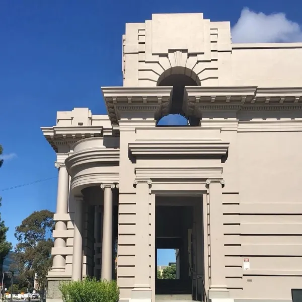 Cream coloured facade of heritage building with blue sky behind