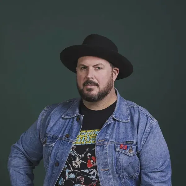 Young man with beard in black hat denim jacket and black tshirt