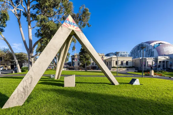 Apex Pyramid Large concrete pyramid made of three struts. The pyramid is placed on green grass near the Geelong Library.