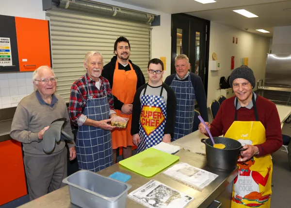 A group of men standing in a kitchen