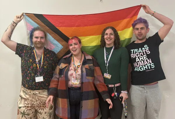 Four people with rainbow flag