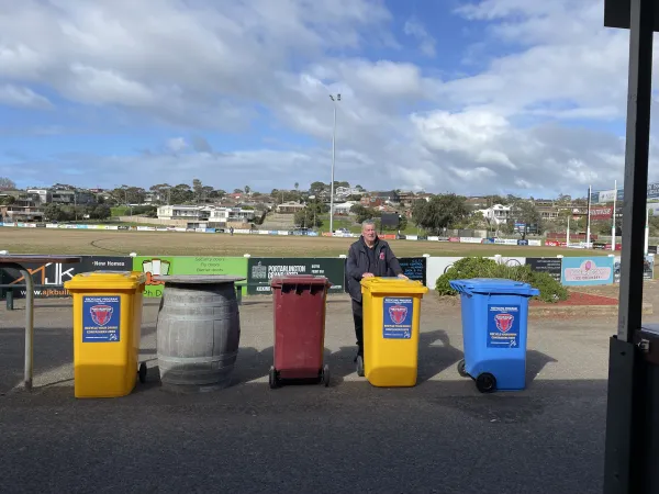Chris with some of the Portarlington Demons' CDS bins Club Treasurer Chris stands in front of a sports oval with some of the clubs CDS bins
