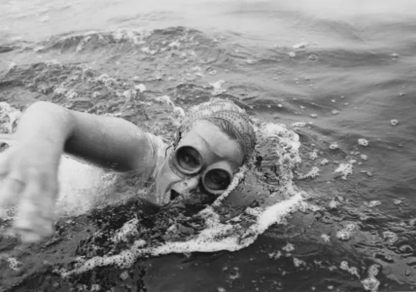 Woman swimming in ocean wearing goggles