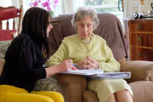 Senior woman discussing care needs with worker.