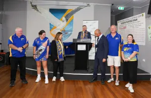 Seven people standing in a line with two unveiling a new plaque