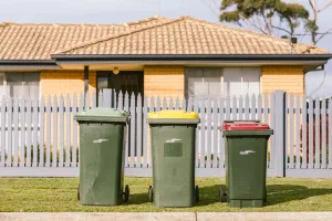 Our standard bin service A green, yellow and red bin outside a house