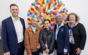 Cr Trent Sullivan and Cultura CEO Rebecca Smith (at rear) with program participants Kio Ner Moo Sanhtwe and Nanah Yohel, and business mentor June O’Brien. Group of five people standing in front of a colourful mural