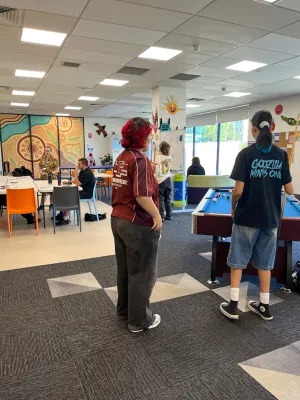 Young people playing pool and eating