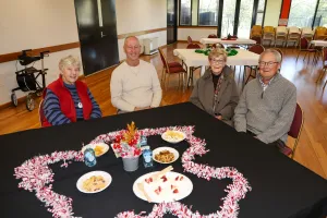 People sitting at a table decorated with Christmas decorations.