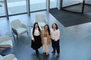 Three women standing and smiling