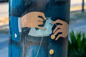 Painted knitting of baby show on bollard
