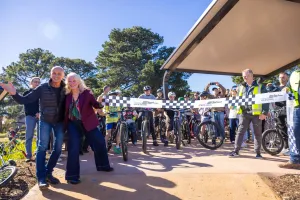 People posing before a ceremonial ribbon