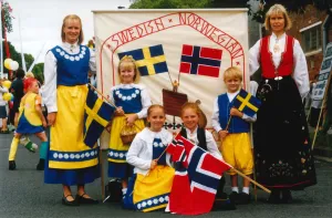 Swedish and Norwegian community members of different ages holding flags