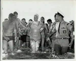 Woman standing in water surrounded by well wishers