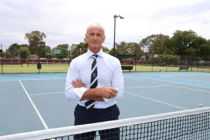 Mayor Stretch Kontelj crossing arms at the tennis net
