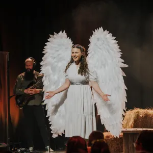 Woman dressed as angel on stage