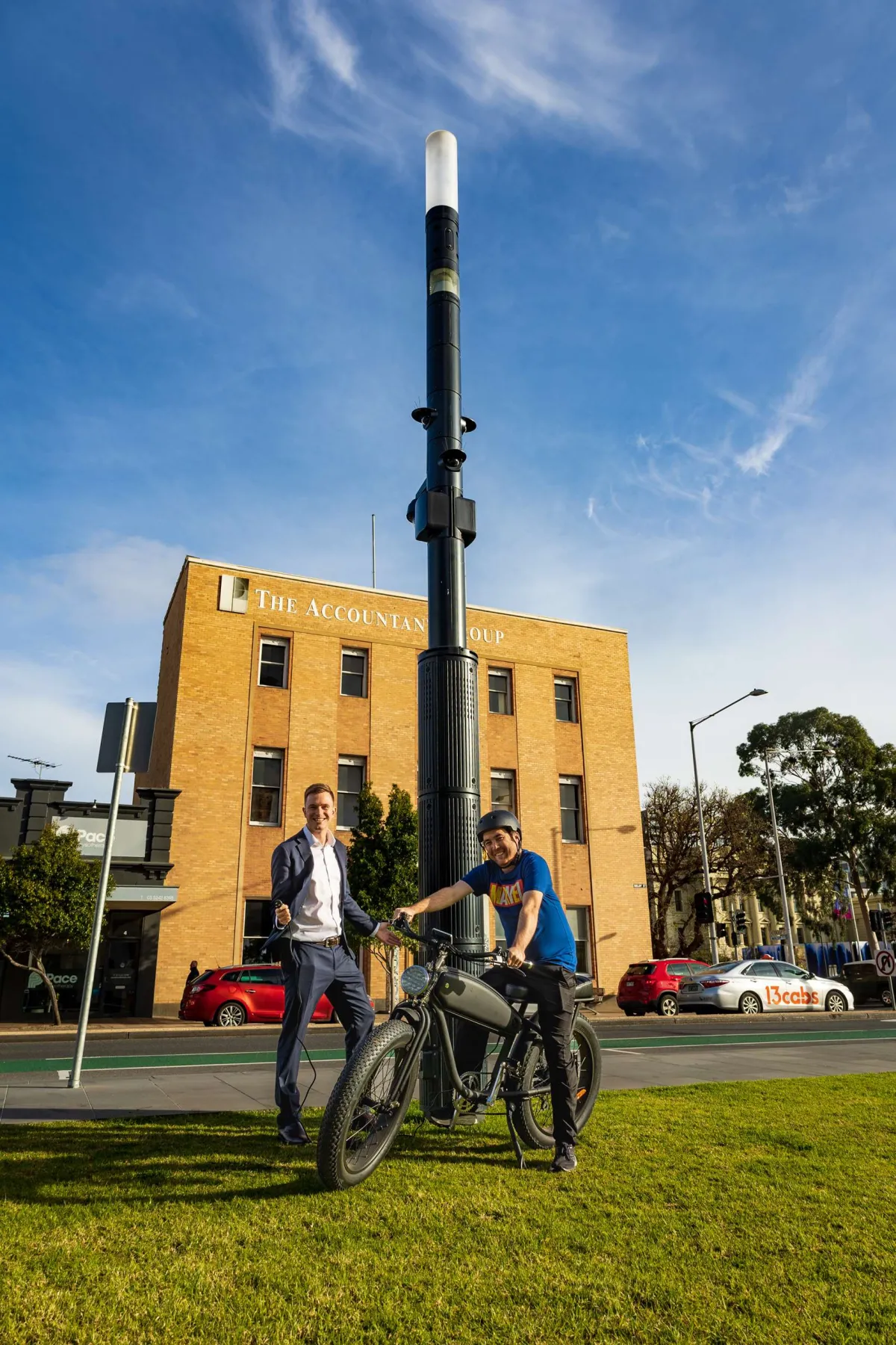 Mayor Trent Sullivan and community member Kieran Yap using a smart street pole (Smart Node) to charge an electric bike.jpg